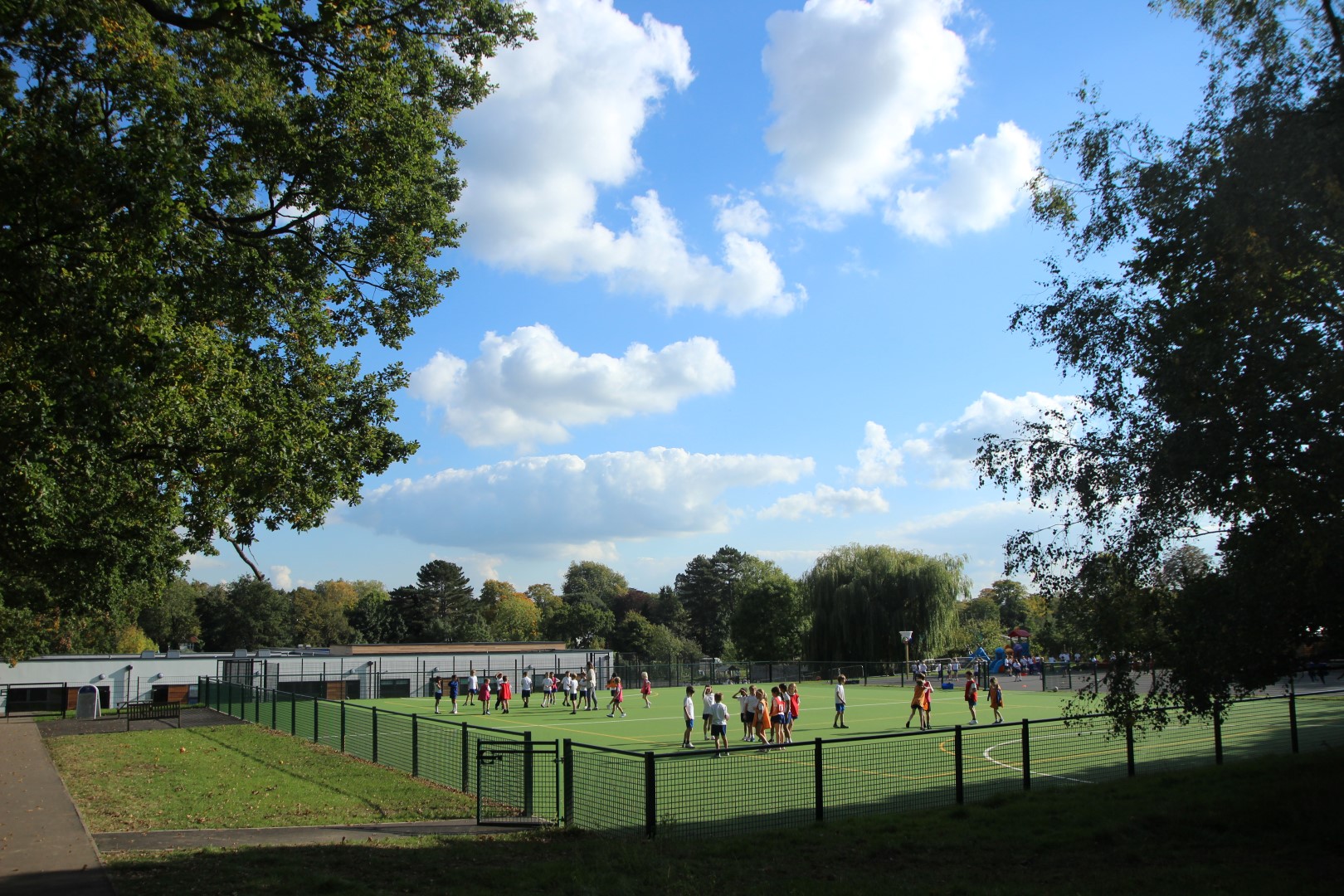 Children playing on a fenced all weather pitch