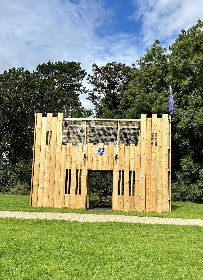 Wooden play castle on the grass in the sun