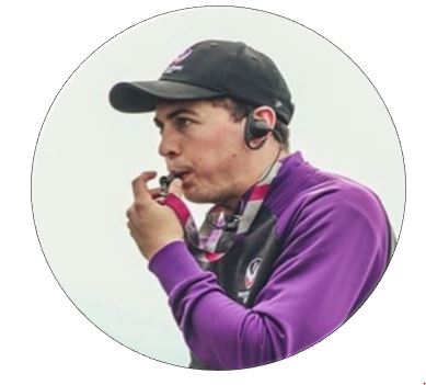 A man in sports clothes is blowing a whistle