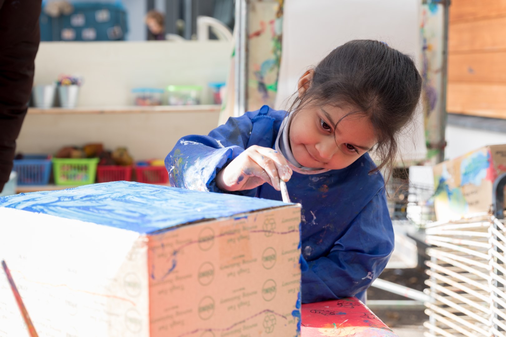 Girl painting a cardboard box