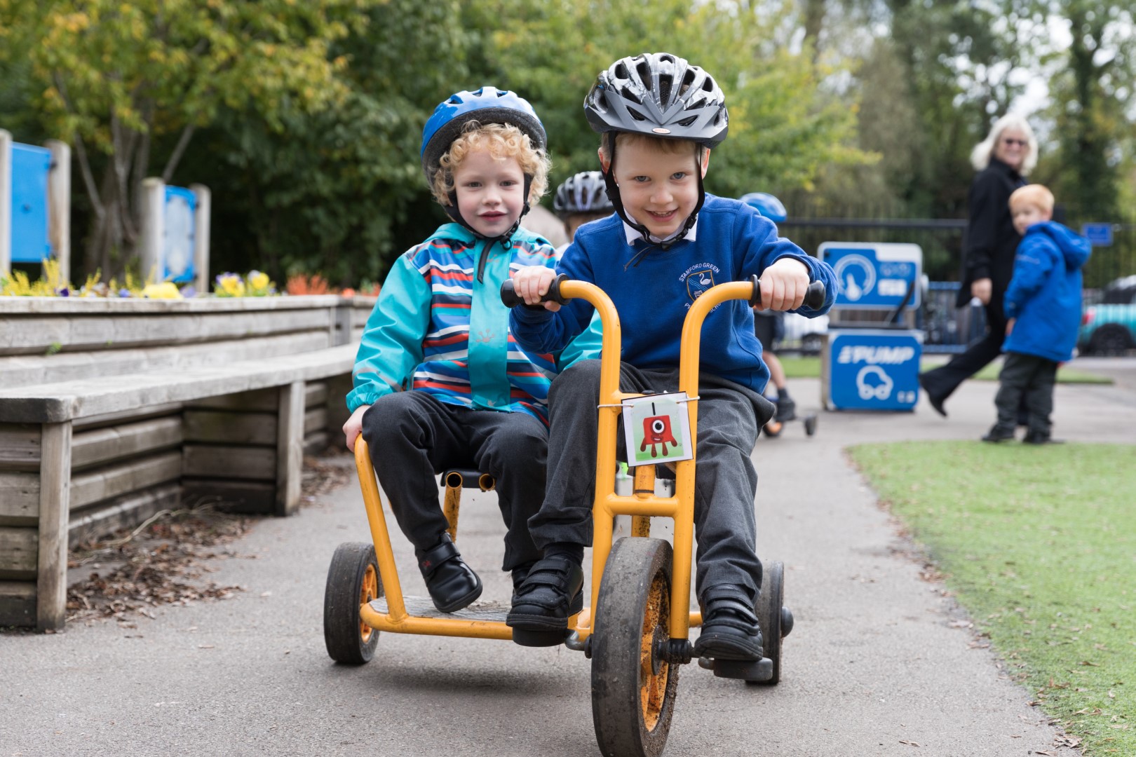 Two boys riding a tricycle