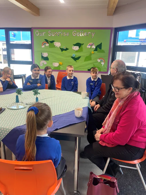 Children talk to local residents at a coffee morning